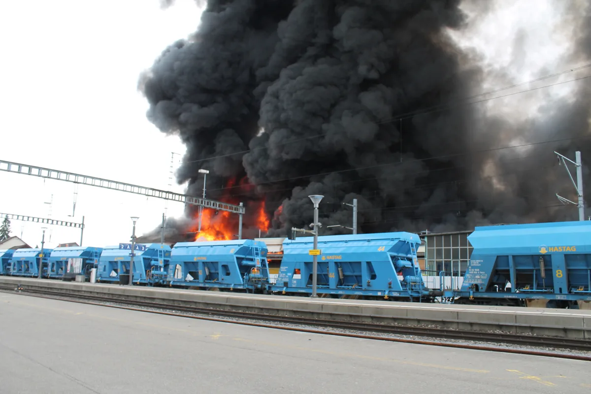 Güterzüge vor dem brennenden Areal.